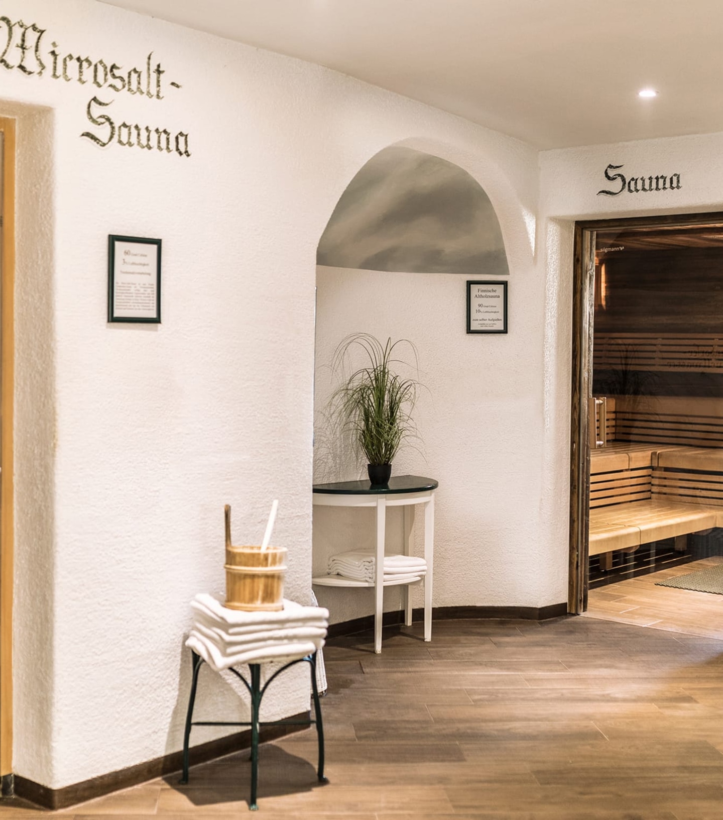 A spa hallway with white walls showing entrances to a Microsalt-Sauna and a wooden Sauna.